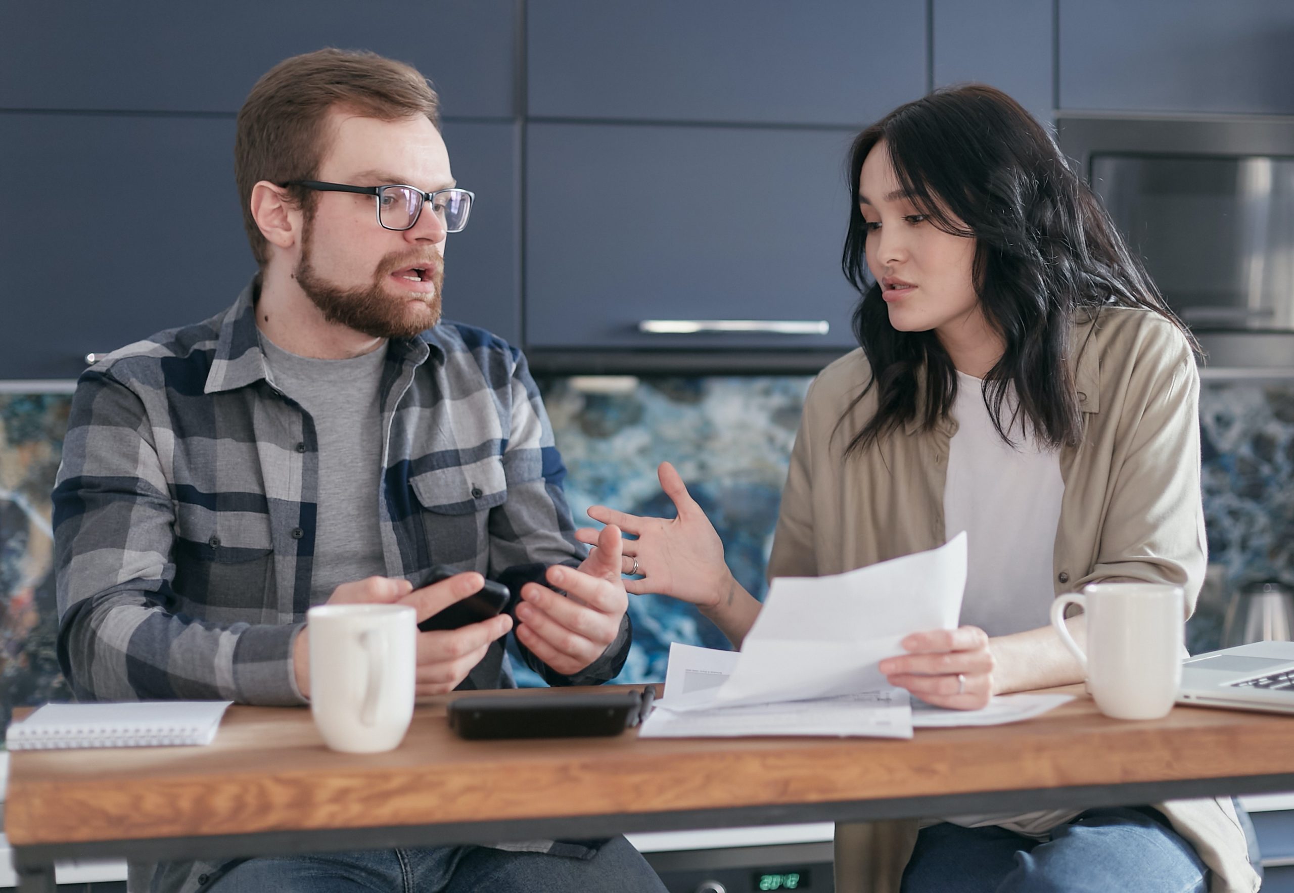 A man and woman talking at a desk