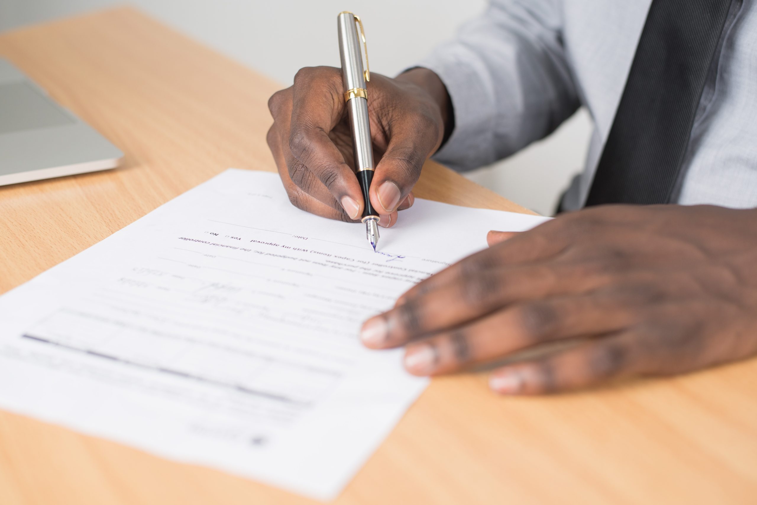 A man writing his signature with a nice pen