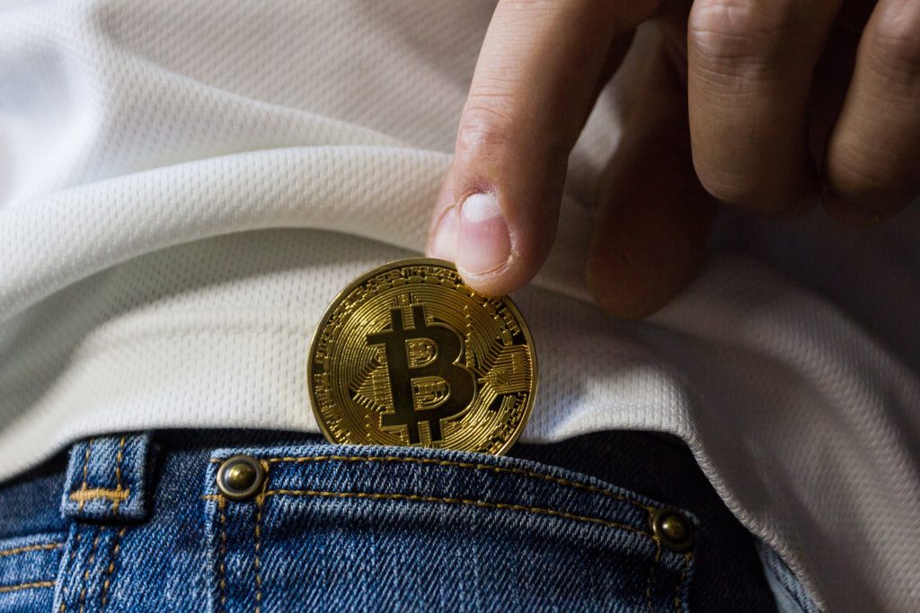 A bitcoin coin going into a jean pocket