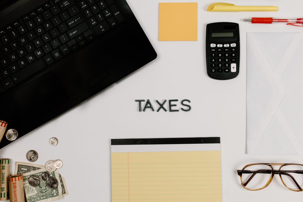 A desk with the word "Taxes" spelled out on it